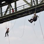 Zwei Personen gesichert an seinem unter einem Eisenträger