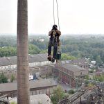 Ein Kletterer steigt in einem Industriegebiet nach oben