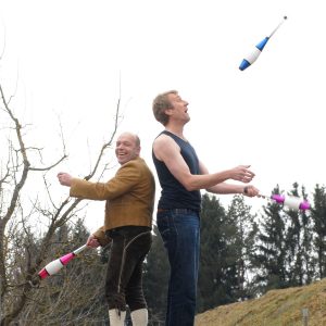 Zwei Personen jonglieren mit Keulen