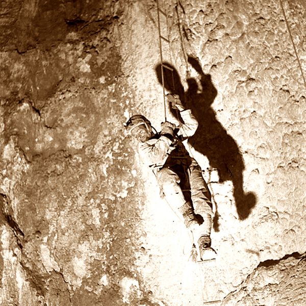 Old picture of a cave climber with old technique